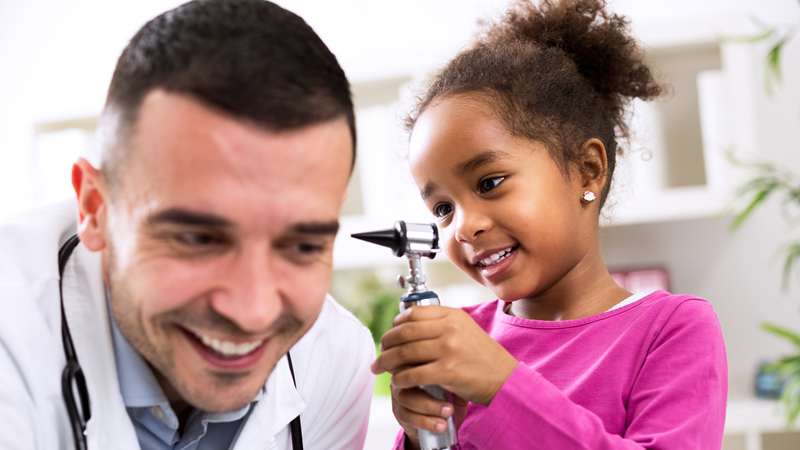 child looking into doctors ear with otoscope