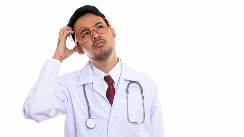 man in white lab coat with glasses and stethoscope scratching head and looking up as if deep in thought