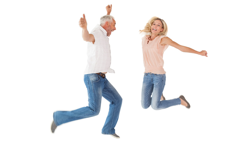 older healthy happy couple jumping for joy