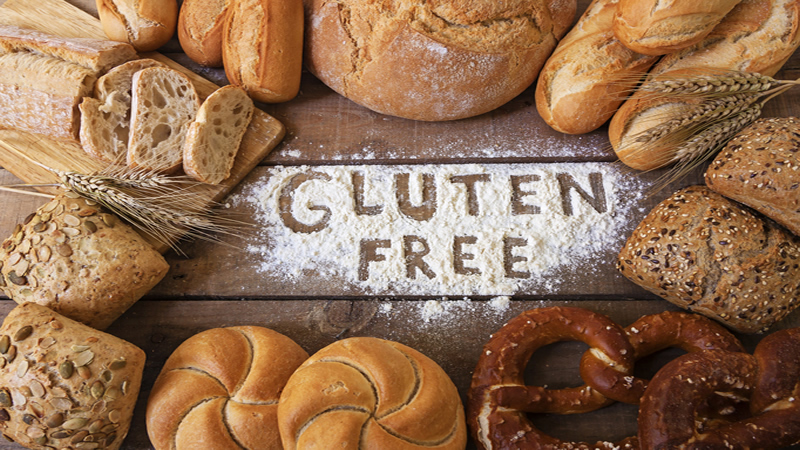 words GLUTEN FREE written in flour surrounded by bread products