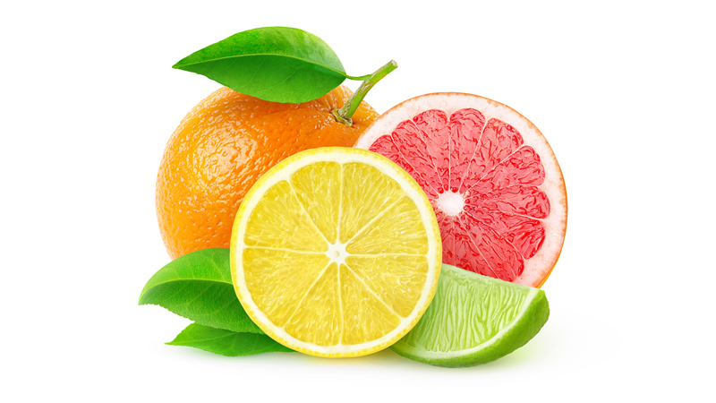 front view lemon slice, lime wedge, grapefruit half and whole orange behind