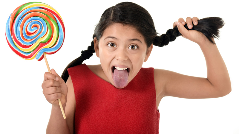 young girl with tongue out holding a huge lollipop and her braid