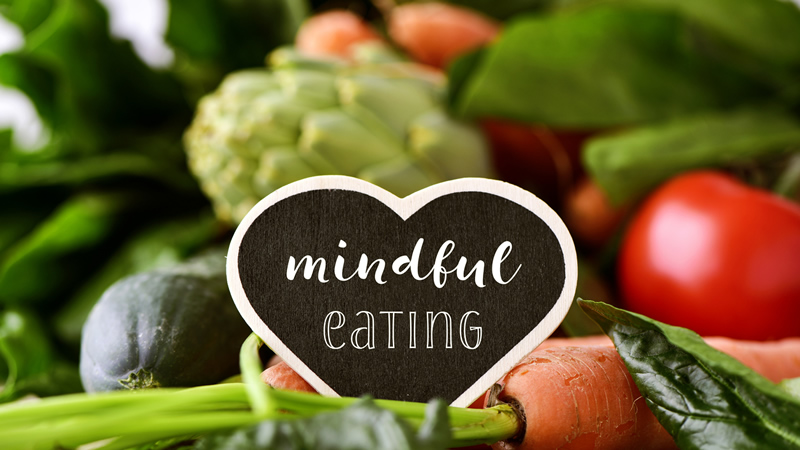 heart with words Mindful Eating with vegetables behind