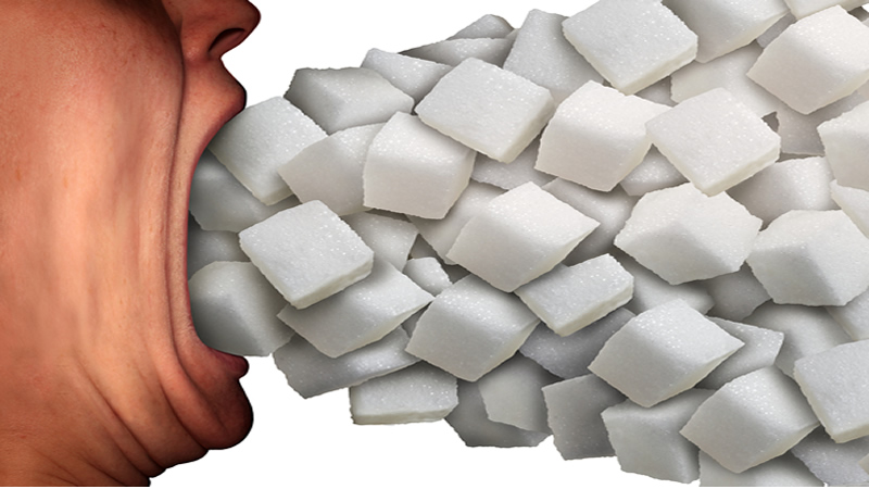 side view of mouth wide open, pile of sugar cubes going in