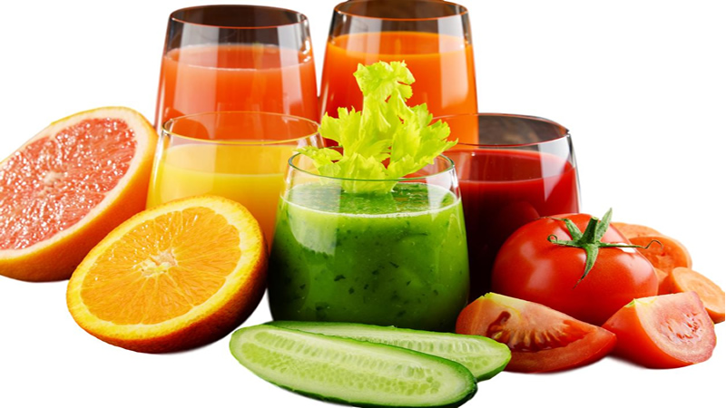 assorted colorful smoothies surrounded by fruit and veg
