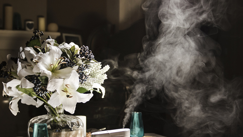 vapour from aromatherapy diffuser with bouquet of lillies