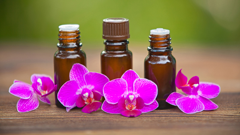 3 brown tincture bottles with purple orchid blooms