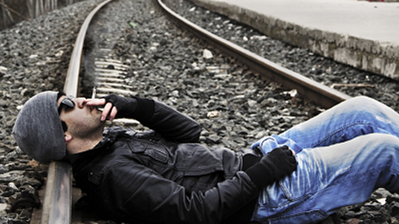 many smoking and lying on train tracks
