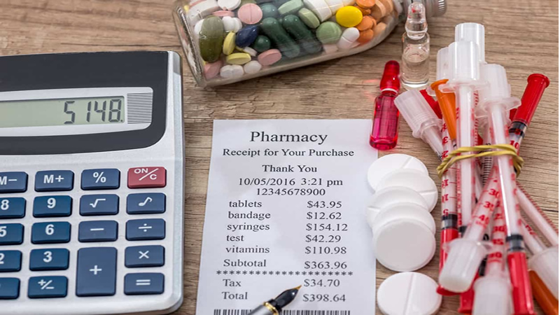 pharmacy receipt beside calculator, capsules, tablets and hypodermic needles