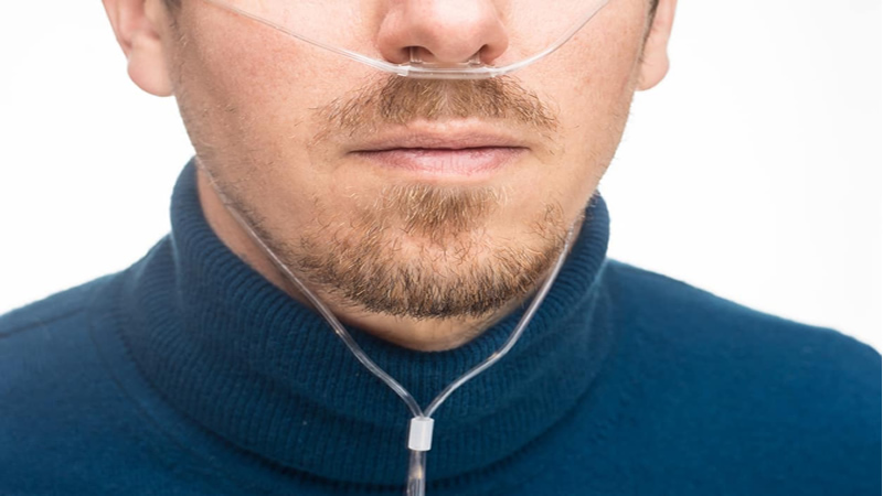 close up of mans lower face with nasal oxygen tubes