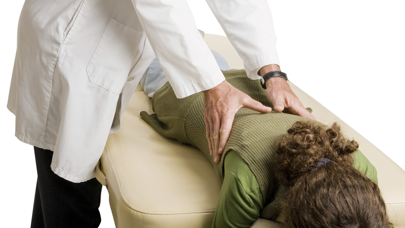 chiropractor treatment showing his hands on womans back