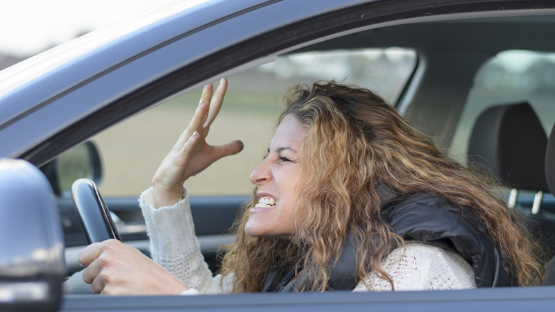side view woman in car with road rage