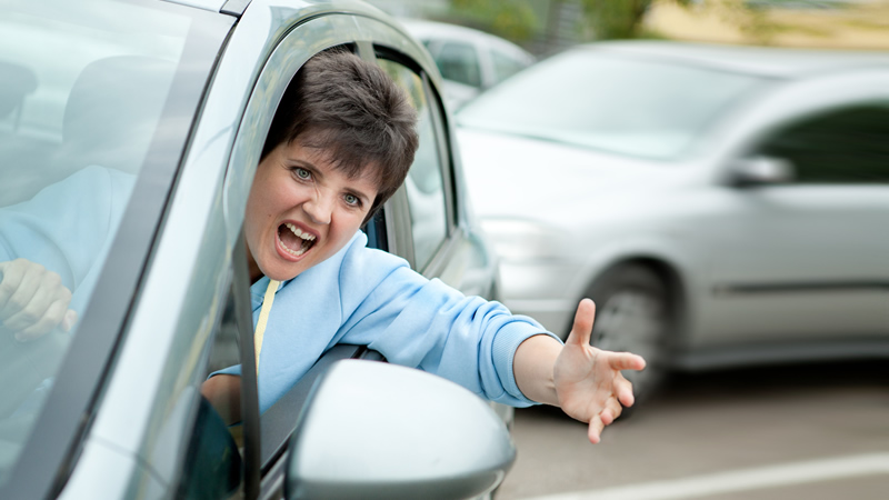 woman in car leaning out with road rage