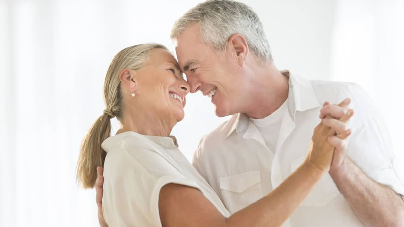 older couple in dance embrace smiling with noses touching