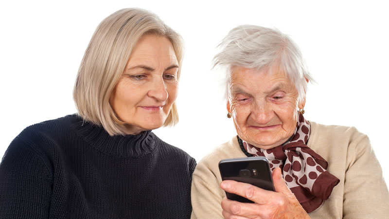 older mother and daughter looking at cell phone