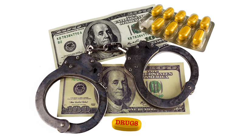 top view drug tablets and handcuffs on cash