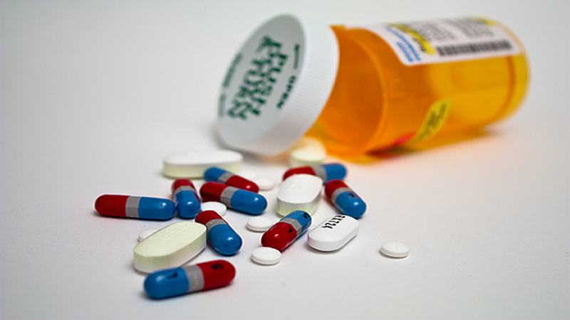 tablets and capsules spilling out of prescription bottle