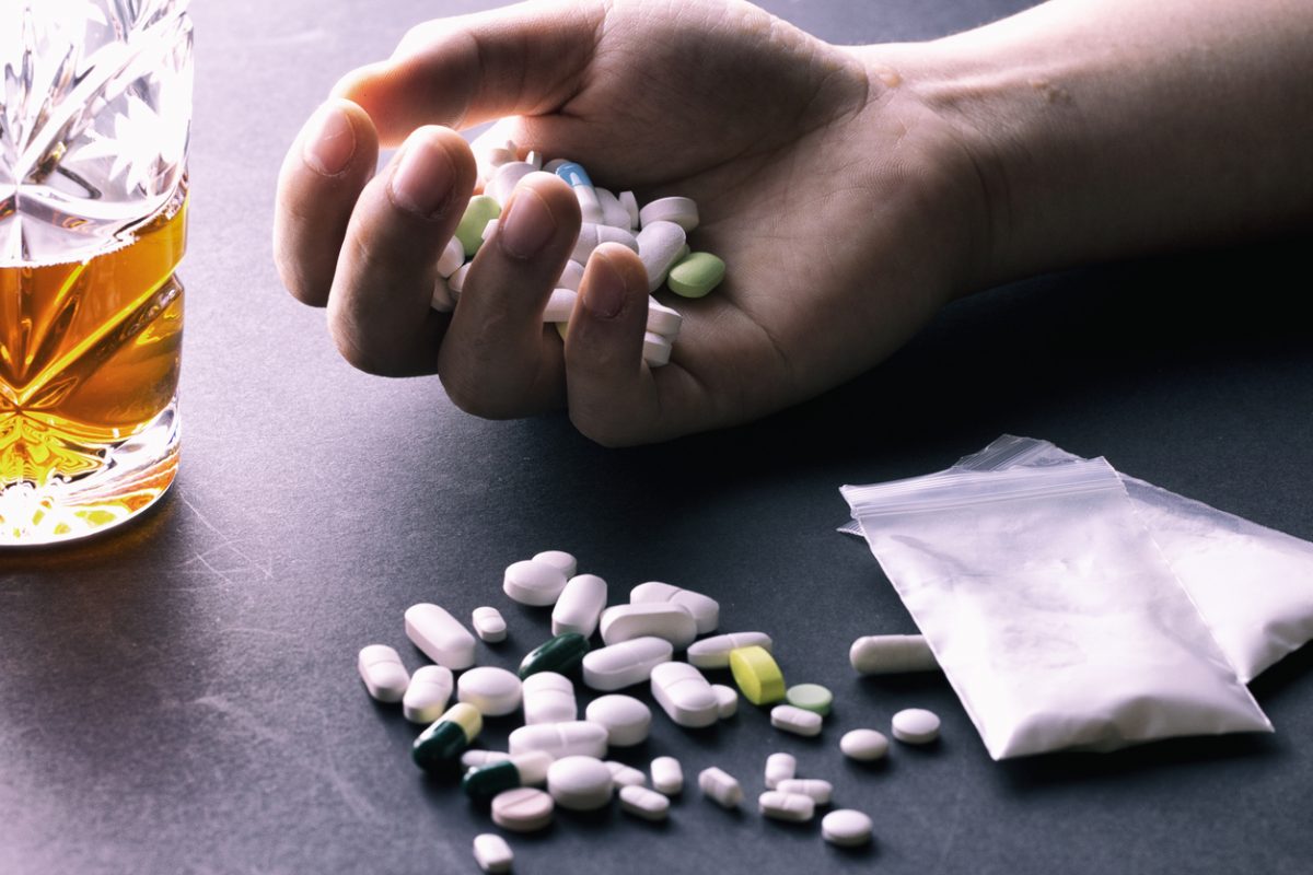 Hand full of pills suggesting addiction