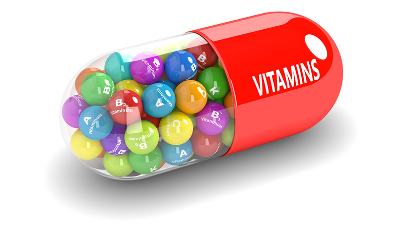 red and clear vitamin capsule full of assorted colorful vitamins
