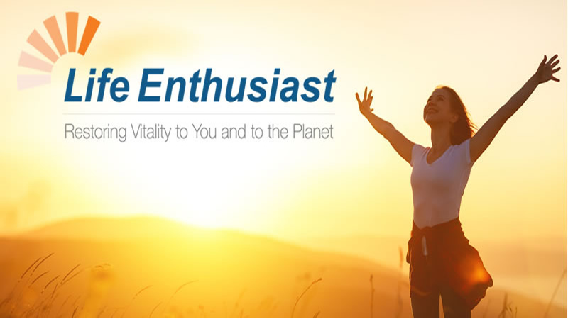 woman with hands held high, sunset beyond with logo and slogan for Life Enthusiast