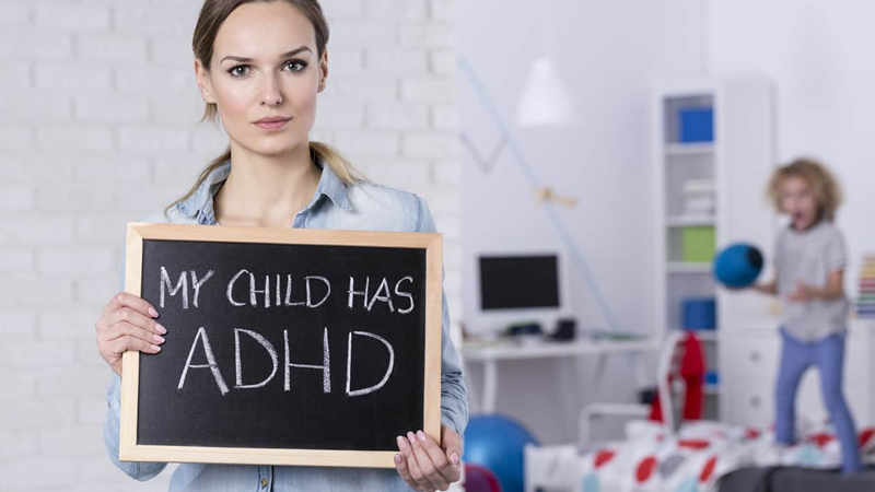 woman holding sign saying My Child has ADHD