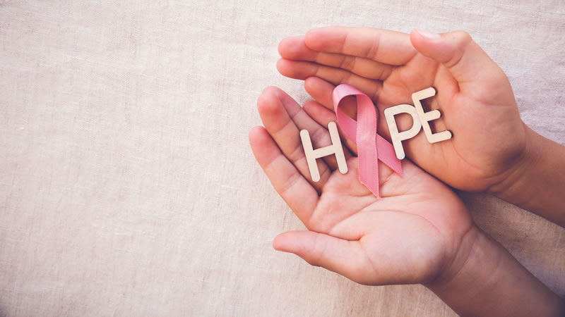 pink ribbon held in hands