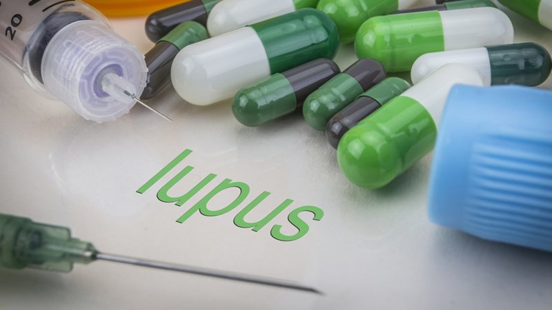 word lupus surrounded by hypodermic needles and capsules