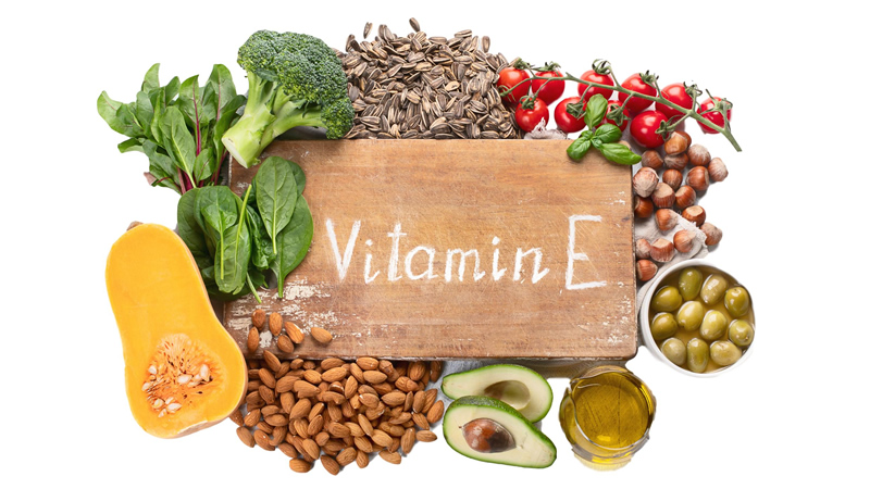 cutting board words Vitamin E surrounded by foods containing it
