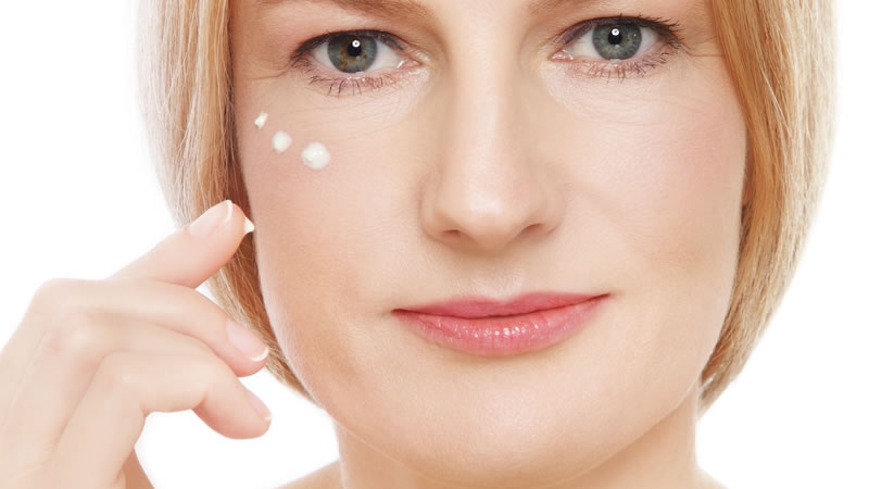 womans glowing healthy face with dots of white moisturizer
