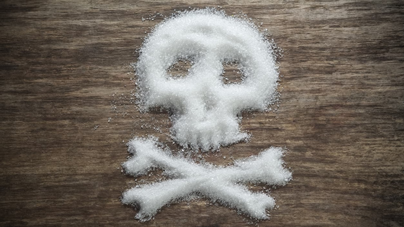 grains of sugar on table in shape of skull and cross bones