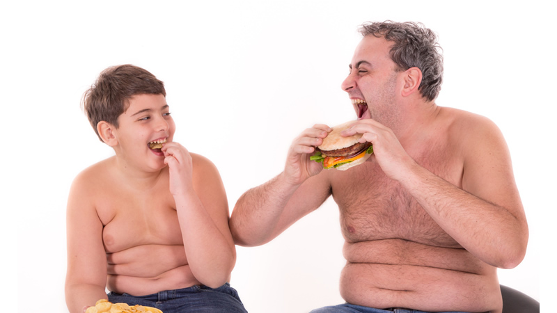 happy teenager and man with bare chests, bulging fat, eating burgers and fries